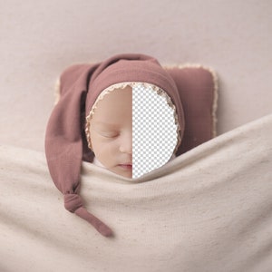 May include: A sleeping baby wearing a mauve knitted hat with a white lace trim, lying on a white blanket.