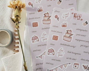 May include: A set of 24 pink and white stickers with illustrations of wedding planning tasks, such as sending invitations, booking a honeymoon, and choosing a dress. The stickers feature the text "Letter Key 2018" and "Love Never Fails".