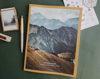 Op de afbeelding: Een geel dagboek met een berglandschap op de omslag. Het dagboek is getiteld "ministry journal" en zegt "17 maanden | wekelijkse werkboek | niet gedateerd".