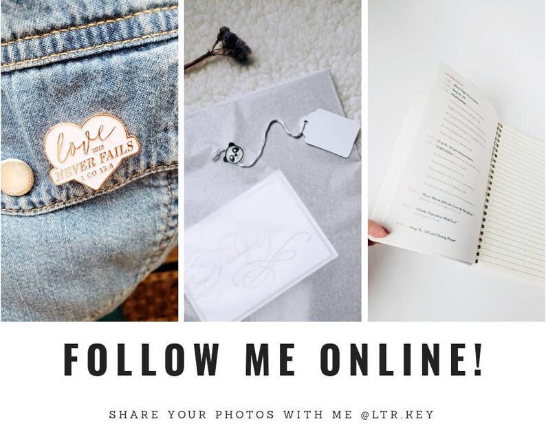 May include: A collage of three images. The first image shows a denim jacket with a wooden heart-shaped pin that says "love never fails 1 Co 13:8". The second image shows a white card with a handwritten design on it. The third image shows a notebook with a white cover and lined pages.