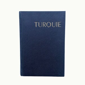 May include: A dark blue book with the word "TURQUIE" printed in silver on the front cover.