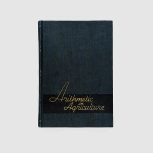 May include: A dark blue hardcover book with the title "Arithmetic in Agriculture" printed in gold lettering on a black band.