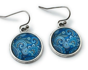 May include: A pair of silver dangle earrings with blue and white paisley patterned round glass cabochons.