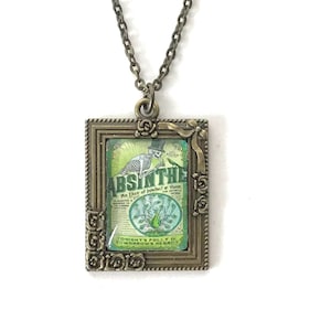 May include: A bronze pendant necklace with a square frame featuring a vintage illustration of a skeleton holding a bottle of absinthe. The illustration is surrounded by a decorative floral border. The text on the illustration reads "Absinthe An Elixir of Instinct & Vision Tonight's Folly is Tomorrow's Regret."