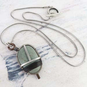 Collar ecléctico artesanal vintage de Thomas Mann en plata esterlina con piedra verde de río envuelta en metal mixto