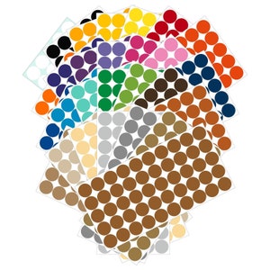 May include: A collection of colorful round stickers in various shades, including black, blue, green, yellow, and brown. The stickers are arranged in a fan-like pattern, with each sheet displaying a single color. The stickers are on a white background.