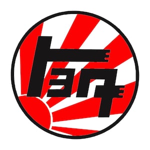 May include: A circular logo featuring the Japanese word "Toyota" in black, stylized with a unique font. The logo is set against a background of red rays emanating from a white sun, all enclosed within a black border.