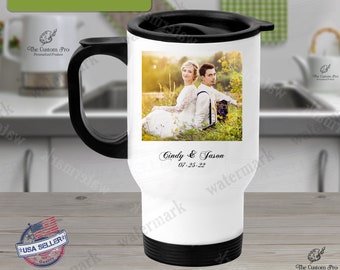 Può includere: Tazza da viaggio bianca con manico e coperchio neri. La tazza ha una foto di una coppia seduta su una collina erbosa con il testo "Cindy & Jason 07-25-22" stampato sotto la foto.