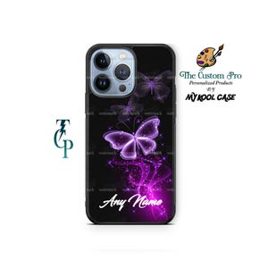 May include: Black iPhone case with a purple butterfly design. The butterfly is glowing and has a trail of purple sparkles. The text "Any Name" is printed on the case.