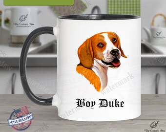 May include: White ceramic coffee mug with a black rim and handle. The mug features a colorful illustration of a Beagle dog with the name "Boy Duke" printed below the image.