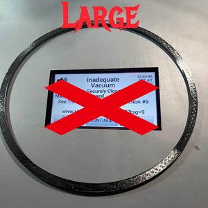 May include: A black ring with a red X over a screen that reads "Inadequate Vacuum Securely Closed" with the text "32:43:45" and "2tsg=9" on the screen.