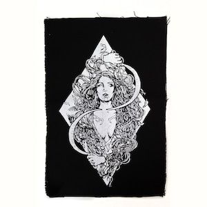 Puede incluir: Parche rectangular negro con una ilustración blanca de una mujer con cabello largo, encerrada en un rombo. La mujer sostiene una hoz. El parche tiene un borde en bruto sin terminar.