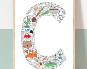 May include: A white framed print featuring a large letter C formed from colourful doodles. The doodles include a carrot, a caterpillar, a camera, a cactus, a cloud, a crab, a crocodile, a cat, a cupcake, a birdcage, a tent, a car, a cricket bat, a ball, a clock, and a candle. The text "CHARLIE 4TH APRIL 2022" is at the bottom of the print.