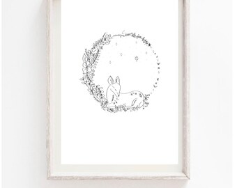 Puede incluir: Un dibujo en blanco y negro de un ciervo descansando dentro de una corona floral circular. El ciervo está acostado con la cabeza apoyada en sus patas delanteras. La corona está hecha de varias flores y hojas.