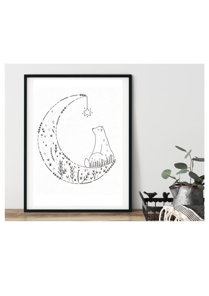 Puede incluir: Ilustraci&oacute;n en blanco y negro de un oso sentado en una luna creciente hecha de flores y hojas. Una estrella cuelga de la parte superior de la luna.