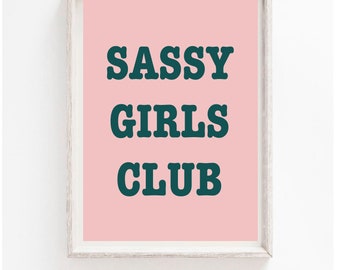 May include: A framed print with a pink background and the text "SASSY GIRLS CLUB" in dark teal.