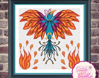 May include: A framed cross-stitch pattern featuring a stylized bird with vibrant orange, purple, and blue wings, a blue body, and a long tail. The bird is surrounded by orange flames on a white background. The text Stitch e Doodle is visible.