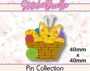 May include: A decorative pin featuring a yellow tabby cat sitting in a brown woven basket with colorful yarn balls and two knitting needles. The text StitcheDoodle and Pin Collection are visible, along with the dimensions 40mm x 40mm.