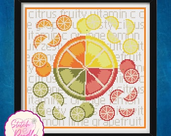 May include: A framed cross-stitch pattern featuring a large central citrus slice divided into orange, yellow, green, and pink segments. Smaller fruit slices surround the center, set against a background of repeating text including citrus, fruity, vitamin c, lemon, and grapefruit.