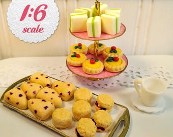 May include: A 1:6 scale miniature tea set featuring a two-tiered pink stand holding square white cakes with green stripes and round yellow tarts with red centers. A rectangular tray holds blueberry scones and jam-filled biscuits next to a white cup.