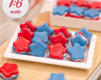 May include: A white plate filled with red and blue star-shaped cookies. The cookies are arranged in a random pattern and are all the same size. The plate is on a wooden surface.