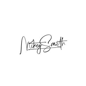 May include: A black signature on a white background. The signature reads "Mikey Smith" in a cursive script. The letters are connected and flow smoothly, with a line underlining the name.