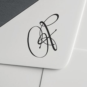 May include: A black, elegant cursive monogram design on a white surface. The monogram features intertwined letters, creating a sophisticated and artistic visual element. The design is simple yet eye-catching.