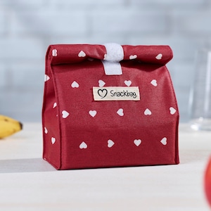 Könnte beinhalten: Rote Lunch-Tasche mit weißen Herzen und einem weißen Etikett mit der Aufschrift "Snackbag".