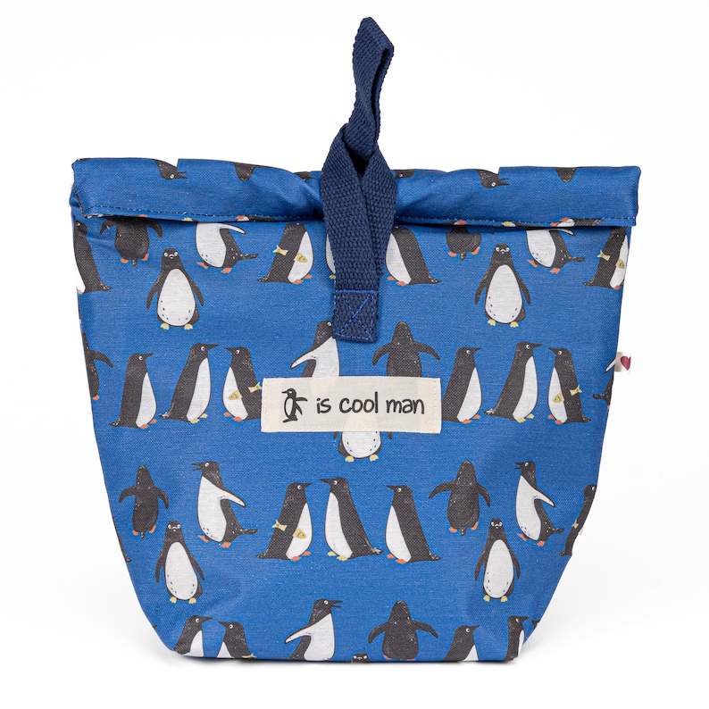 May include: A blue reusable lunch bag with a penguin pattern and a navy blue drawstring. The bag has a white label with the text "is cool man".