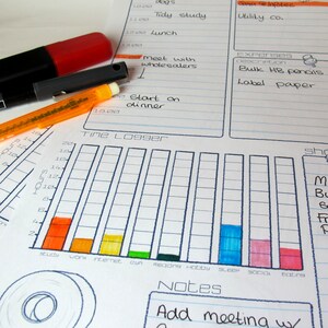 May include: A planner with a time logger graph, notes section, and expense descriptions. The time logger has colorful bars representing activities. A red marker, black pen, and orange eraser are on the planner. The planner includes the text "meet with wholesalers" and "Start on dinner."