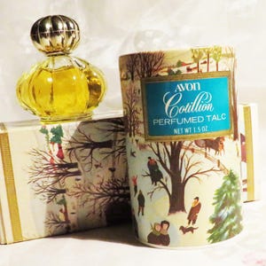 May include: Vintage Avon Cotillion Perfumed Talc and perfume bottle. The talc container is cylindrical with a winter scene illustration and the text "AVON Cotillion PERFUMED TALC NET WT 1.5 OZ". The perfume bottle is yellow with a gold-colored cap.