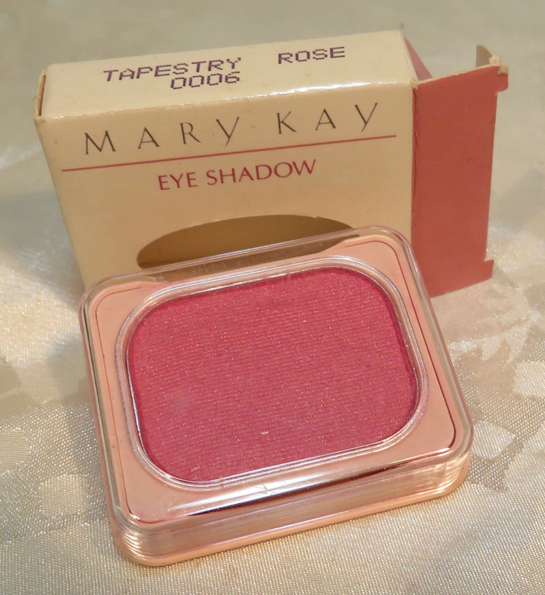 May include: A pink eye shadow compact with the words 'Mary Kay' and 'Eye Shadow' printed on the box. The compact is labeled 'Tapestry 00006 Rose'.