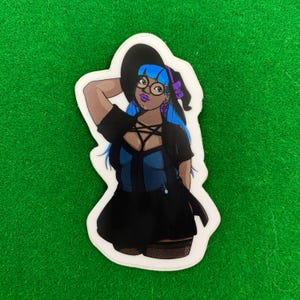 May include: A sticker depicting a cartoon character with blue hair, glasses, and a witch's hat. The character wears a black dress with a blue bodice and fishnet stockings. The sticker is set against a green backdrop.