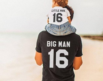 May include: A black t-shirt with the text "BIG MAN 16" printed on the back. A child is wearing a white t-shirt with the text "LITTLE MAN 16" printed on the front.