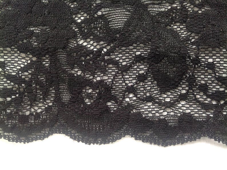 Large Dentelle de Calais élastiquée noire avec motifs floraux et finition avec coquilles. image 3