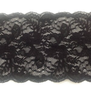 Large Dentelle de Calais élastiquée noire avec motifs floraux et finition avec coquilles. image 2