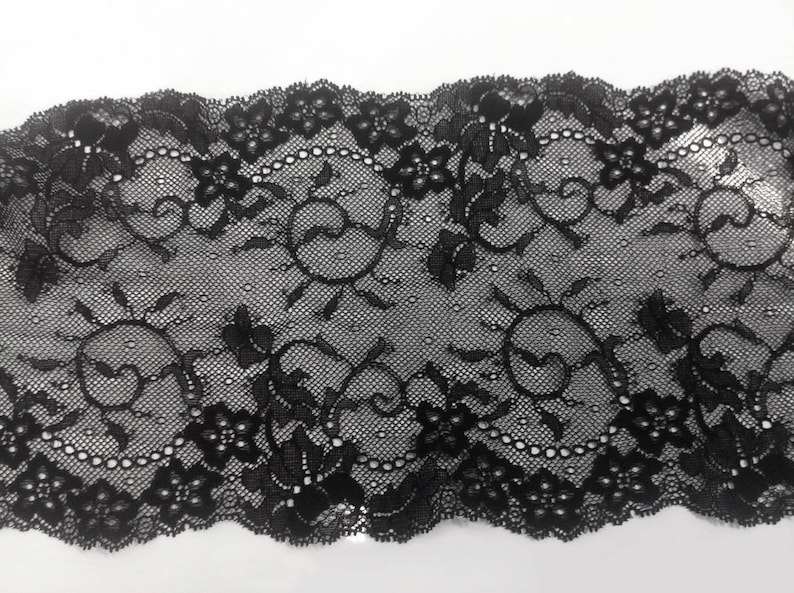 Dentelle de Calais, élastique, noire, avec motifs floraux, des arabesques mélangées, finition en coquilles, spécial lingerie vendu au mètre image 1