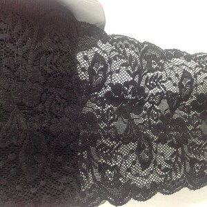 Large Dentelle de Calais élastiquée noire avec motifs floraux et finition avec coquilles. image 4