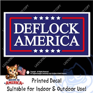 May include: A rectangular decal featuring a dark blue background with a white border and a thin red rectangular outline. The text DEFLOCK AMERICA is printed in white capital letters, flanked by five white stars above and five white stars below.