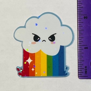 May include: A sticker featuring a cartoon cloud with an angry face and a rainbow. The cloud is white with a light blue outline, and the rainbow has red, orange, yellow, green, and blue stripes. The sticker is approximately 2 inches tall.