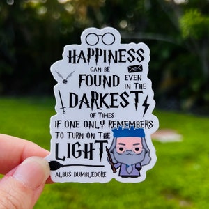 May include: White sticker with a quote from Albus Dumbledore: "Happiness can be found even in the darkest of times if one only remembers to turn on the light." The sticker features a cartoon illustration of Dumbledore with a wand and a lightning bolt.