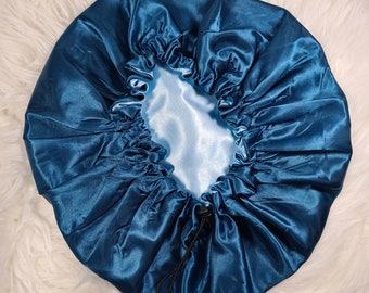 Può includere: Un copricapo da notte in raso blu turchese con un cordoncino nero. Il copricapo è progettato per proteggere i capelli durante il sonno.