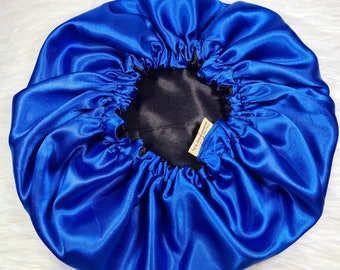 Può includere: Un berretto in raso blu reale con fodera nera. Il berretto ha un design plissettato e un'etichetta piccola che recita "Love & Luxury".