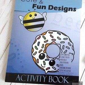May include: A blue activity book cover with a cartoon bee and donut. The title is "Cute & Fun Designs Activity Book". The book includes rope climber pages, connect the dots, word search, fill in the blanks, mazes, unscramble the words, and cut-out and glue pages.