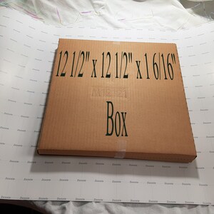 May include: A brown cardboard box with the text "12 1/2" x 12 1/2" x 1 6/16" Box" printed on the front.