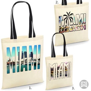 Può includere: Tre borse tote in tela con manici neri. La prima borsa ha una foto di Miami, in Florida, con la parola "MIAMI" in grandi lettere. La seconda borsa ha una foto di una palma con le parole "MIAMI BEACH". La terza borsa ha una foto di Miami, in Florida, con la parola "MIAMI" in grandi lettere.