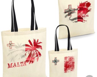May include: Three canvas tote bags with black handles. Each bag features a design related to Malta. One bag has a red palm tree design, another has a red splash design, and the third has a red and white flag design.