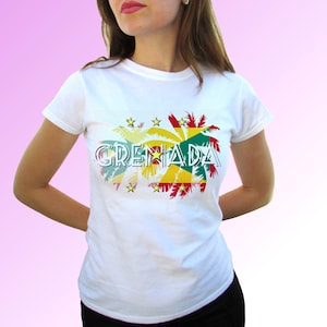 Może przedstawiać: Biała koszulka z nadrukiem graficznym przedstawiającym słowo "GRENADA" w stylizowanym foncie, otoczonym palmami i żółtymi gwiazdami. Palmy są pokryte kolorami flagi Grenady: czerwonym, żółtym i zielonym.