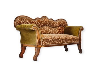 May include: A vintage brown and green patterned velvet tufted sofa with wooden legs and a curved back.