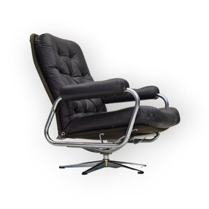 May include: A black leather swivel chair with a chrome frame and a tufted back. The chair has a star-shaped base and is in a reclined position.